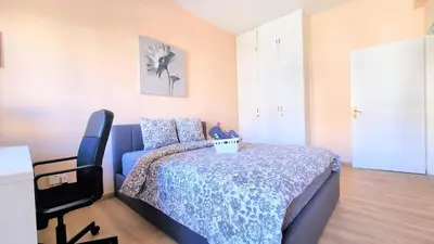 a bedroom with a blue bed and a television at The Urban Oasis - Comfort 2br near the City Center, 200Mbit Internet and Smart TV in Larnaka