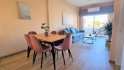 a living room with a table and chairs and a couch at The Urban Oasis - Comfort 2br near the City Center, 200Mbit Internet and Smart TV in Larnaka