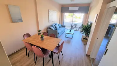a living room with a wooden table and chairs at The Urban Oasis - Comfort 2br near the City Center, 200Mbit Internet and Smart TV in Larnaka