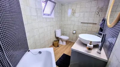 a bathroom with a white sink and a toilet at The Urban Oasis - Comfort 2br near the City Center, 200Mbit Internet and Smart TV in Larnaka