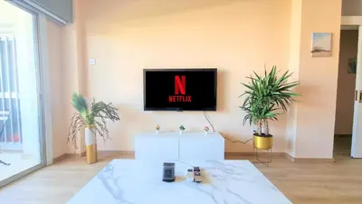 a living room with a tv on a wall with plants at The Urban Oasis - Comfort 2br near the City Center, 200Mbit Internet and Smart TV in Larnaka