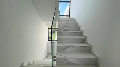 a staircase in a house with a glass railing at By the Bay Villa,3 BR/pool in Protaras