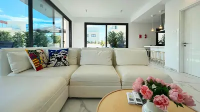 a white couch in a living room with a table at By the Bay Villa,3 BR/pool in Protaras