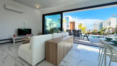 a living room with a white couch and a television at By the Bay Villa,3 BR/pool in Protaras