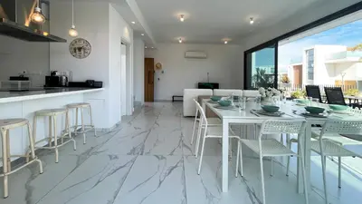 a kitchen and dining room with a white table and chairs at By the Bay Villa,3 BR/pool in Protaras