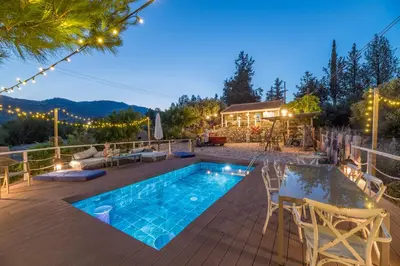 a patio with a swimming pool and a house at Rozana House in Silikou