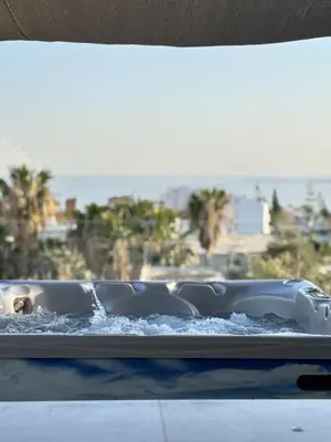 a hot tub filled with water with a view of the ocean at Sant Central Deluxe Apartments in Ayia Napa