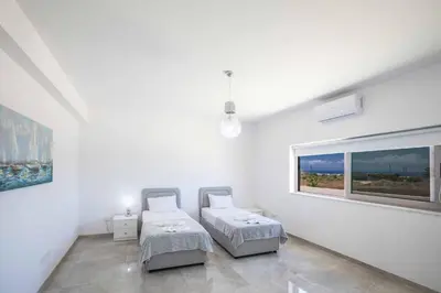 a white room with two beds and a window at Villa Demeter GA98 in Paralimni