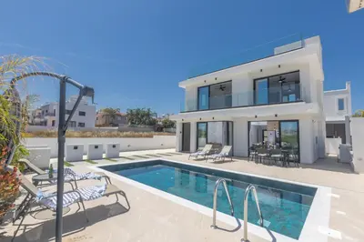 a villa with a swimming pool and a house at Trinity Villa in Paralimni