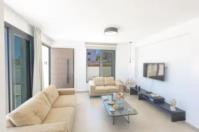 a living room with a couch and a table at Trinity Villa in Paralimni