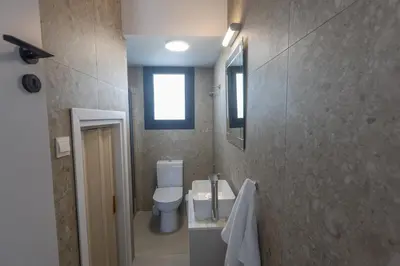 a bathroom with a toilet and a sink and a window at Trinity Villa in Paralimni