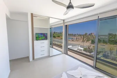 a living room with a ceiling fan and large windows at Trinity Villa in Paralimni