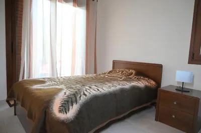 a bedroom with a bed with a nightstand and a window at Kakopetria's Holiday House in Kakopetria