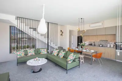 a living room with a green couch and a kitchen at Protaras Elite Pearl Villa Ep17 in Protaras
