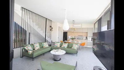 a living room with green couches and a table at Protaras Elite Pearl Villa Ep17 in Protaras
