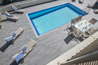 an overhead view of a swimming pool with chairs and a table at Protaras Holiday Villa Dv1 in Protaras