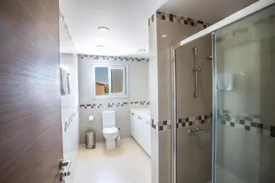 a bathroom with a toilet and a glass shower at Protaras Holiday Villa Dv1 in Protaras
