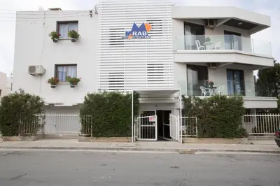 a white building with a akidas sign on it at Ayia Napa Holiday Apartment So2 in Ayia Napa