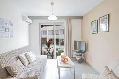 a living room with a couch and a tv at Ayia Napa Holiday Apartment So2 in Ayia Napa