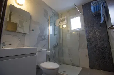 a bathroom with a shower and a toilet and a sink at Ayia Napa Holiday Apartment So7 in Ayia Napa