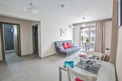 a living room with a couch and a table at Ayia Napa Holiday Apartment So4 in Ayia Napa