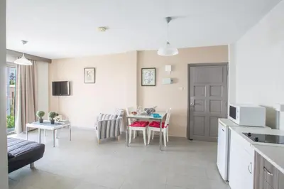 a kitchen and living room with a table and chairs at Ayia Napa Holiday Apartment So4 in Ayia Napa