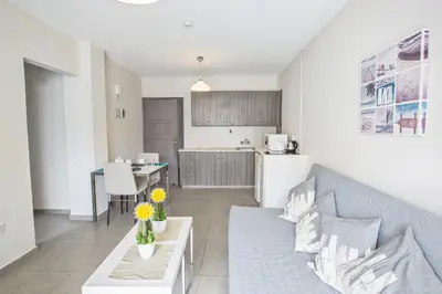a living room with a couch and a kitchen at Ayia Napa Holiday Apartment So8 in Ayia Napa