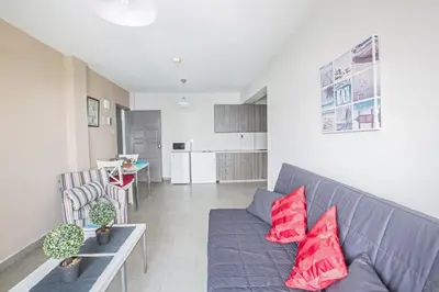 a living room with a blue couch and red pillows at Ayia Napa Holiday Apartment So9 in Ayia Napa