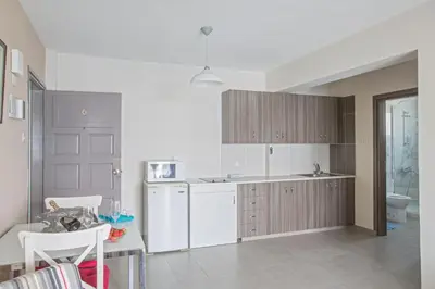 a kitchen with a white refrigerator and a table at Ayia Napa Holiday Apartment So9 in Ayia Napa