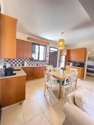 a kitchen and living room with a table and chairs at Pervolina countryside by the sea in Pervolia