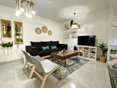 a living room with a black couch and a table at Peaceful 2 bedroom Flat in Engomi