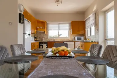a kitchen with a table with a bowl of fruit on it at Villa Mespila_ Ayia Napa in Ayia Napa