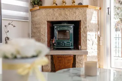 a stone fireplace with a green stove in it at Villa Mespila_ Ayia Napa in Ayia Napa