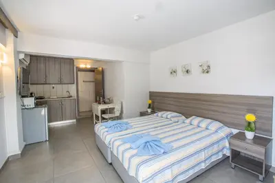 a bedroom with a large bed and a kitchen at Ayia Napa Holiday Apartment Ss1 in Ayia Napa