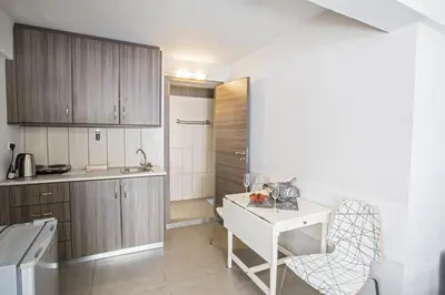 a kitchen with wooden cabinets and a white table at Ayia Napa Holiday Apartment Ss1 in Ayia Napa