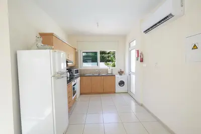 a kitchen with a white refrigerator and a sink at Protaras Holiday Villa Dv27 in Protaras