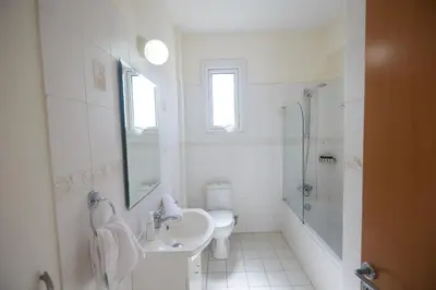 a white bathroom with a sink and a shower at Protaras Holiday Villa Dv27 in Protaras