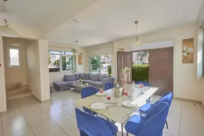 a dining room with a table and blue chairs at Protaras Holiday Villa Dv27 in Protaras