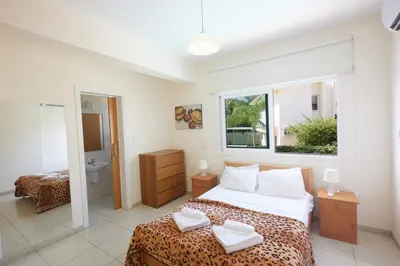 a bedroom with a large bed and a bathroom at Protaras Holiday Villa Dv27 in Protaras