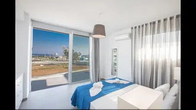 a bedroom with a bed and a large window at Protaras Olivine Villa Ol5 in Protaras