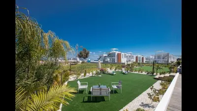 a lawn with tables and chairs in a park at Protaras Olivine Villa Ol5 in Protaras