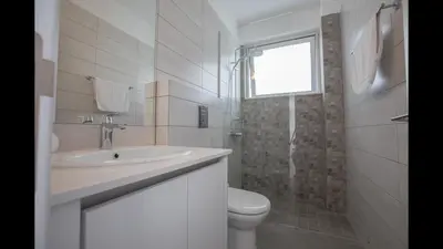 a bathroom with a sink and a toilet and a window at Protaras Olivine Villa Ol5 in Protaras