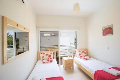 a small room with two beds and a window at Protaras Delfini Villa Dv4 in Protaras