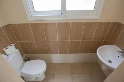 a bathroom with a toilet and a sink and a window at Protaras Delfini Villa Dv4 in Protaras