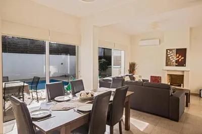 a dining room with a table and a couch at Protaras Delfini Villa Dv5 in Protaras
