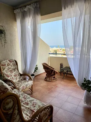 a living room with two chairs and a window at Carisa Holiday rooms in Larnaka