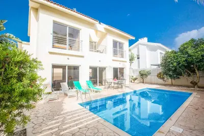 a villa with a swimming pool in front of a house at Villa Delfini 5 in Protaras