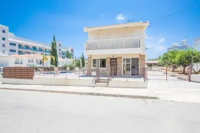 a building with a fence in front of a street at Villa Delfini 16 in Protaras