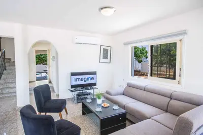 a living room with a couch and a tv at Villa Delfini 16 in Protaras