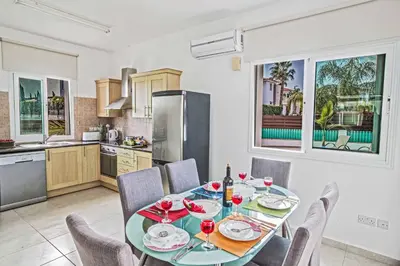 a kitchen and dining room with a table and chairs at Villa Mesogeios ME25 in Protaras
